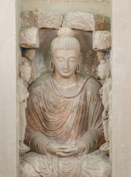<h3>Gold plated Buddha in meditation</h3> <p>4th-5th Cent. AD<br /> Jaulian<br /> Originally set within a niche, the gilded stucco sculpture depicts the Buddha in meditation pose with both hands resting in the lap. The back of his right hand is leaning on the palm of the left hand. This gesture symbolizes wisdom during his final meditation under the Bodhi tree when he attained enlightenment. The loose robe covers both his shoulders. The central figure of the Buddha is flanked by attendant Bodhisattvas.</p>