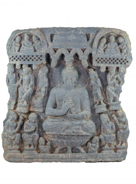 <h3>Buddha in preaching pose (dharmachakra-mudra)</h3> <p>2 Century CE<br /> Provenance unknown, confiscated object<br /> 66.5 x 63 x 8.5cm<br /> In this elaborate relief sculpture the Buddha is represented in a teaching pose at the center of the composition. He sits on a lotus throne with his hands held at the level of his chest in a ritual gesture, the dharmachakra-mudra. In this gesture the thumb and index finger touch, creating a circle that symbolizes an uninterrupted flow of wisdom..</p> 