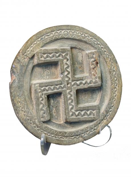 <h3>Toilet Tray with Swastika symbol</h3> <p>Sirkap<br /> 1st to 2nd century CE<br /> Toilet trays or palettes are stone artefacts that were discovered from domestic contexts in Sirkap. These objects were likely used for a variety of purposes: they may have functioned as containers for cosmetics, liturgical vessels, libation trays as well as votive objects. Carved out of grey schist, this toilet tray sports a Swastika design on the inner side.</p>