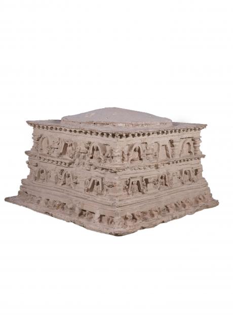 <h3>Votive Stupa</h3>  <p>Jaulian<br /> Votive stupas were constructed by monastic or lay devotees in the sacred areas of monasteries or near prominent stupas to commemorate visits or attain merit. The exhibit is the base of a votive stupa from Taxila. There are four rows of panels with niches carrying seated Buddha figures, interspersed with Corinthian columns. At the base, there is row of lion heads and Atlas-type figures supporting the pedestal.</p>